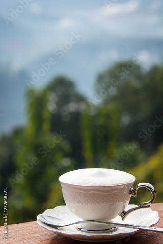 Coffee in white cup at the morning time have mountain background