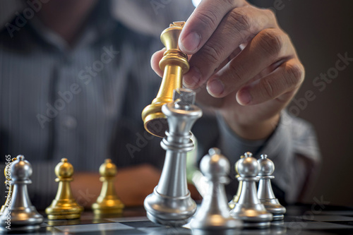 Gold and silver chess with player, Intelligent businessman playing chess game competition to planning business strategic to development for win and success