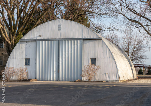 Vintage quonset hut, corrugated metal building with 2 windows. Half circle round building common after WWII. Concepts of architecture, construction, history