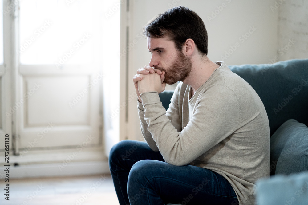 Young man suffering from depression hopeless and alone at home