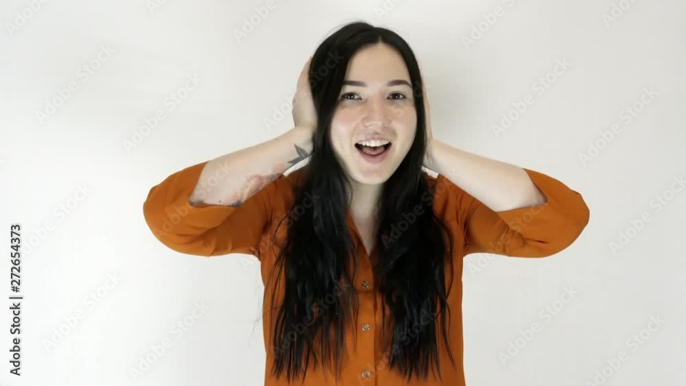A young woman covers her ears with her hands. She refuses to listen to the information. A young woman covers her ears with her hands. She refuses to listen to the information.