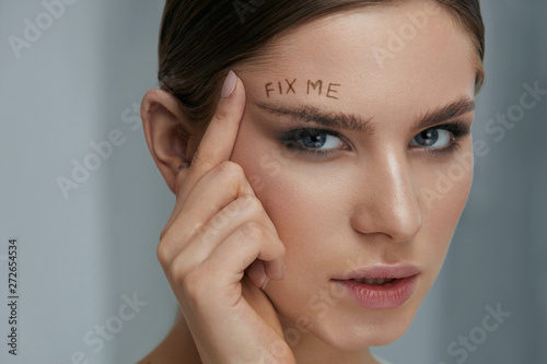 Beauty makeup. Woman face with messy eyebrow and fix me on skin