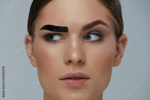 Beauty makeup. Woman coloring eyebrow with brow gel tint