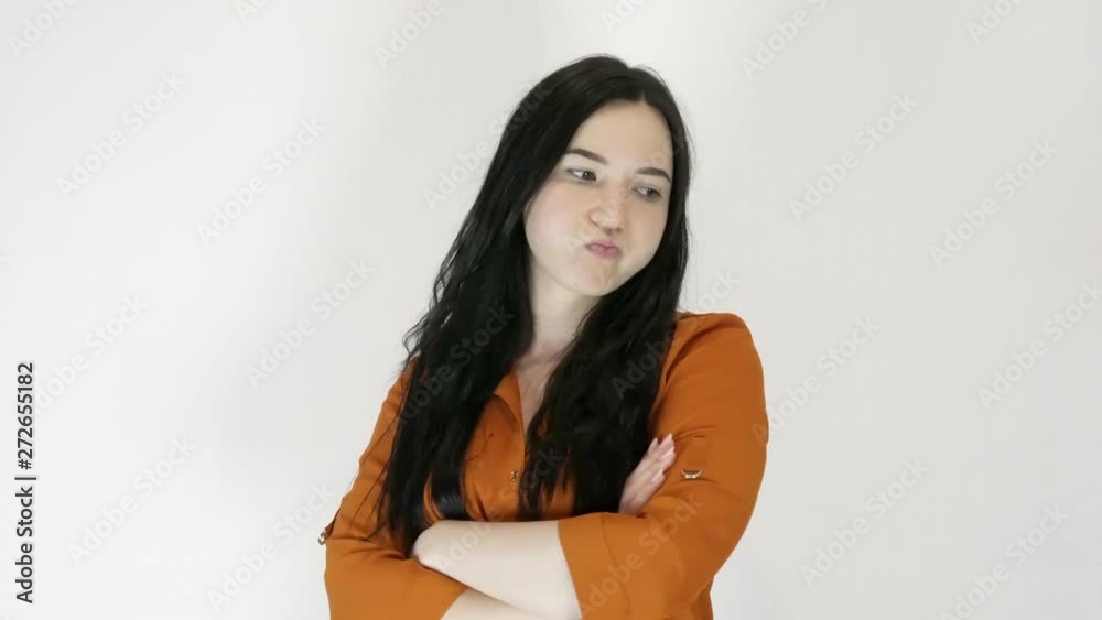 A young woman shows her displeasure and rage. She portrays emotions. Light background A young woman shows her displeasure and rage. She portrays emotions. Light background