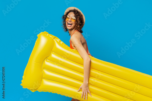 Tableau sur toile Cheerful black girl going to poll with yellow inflatable mattress