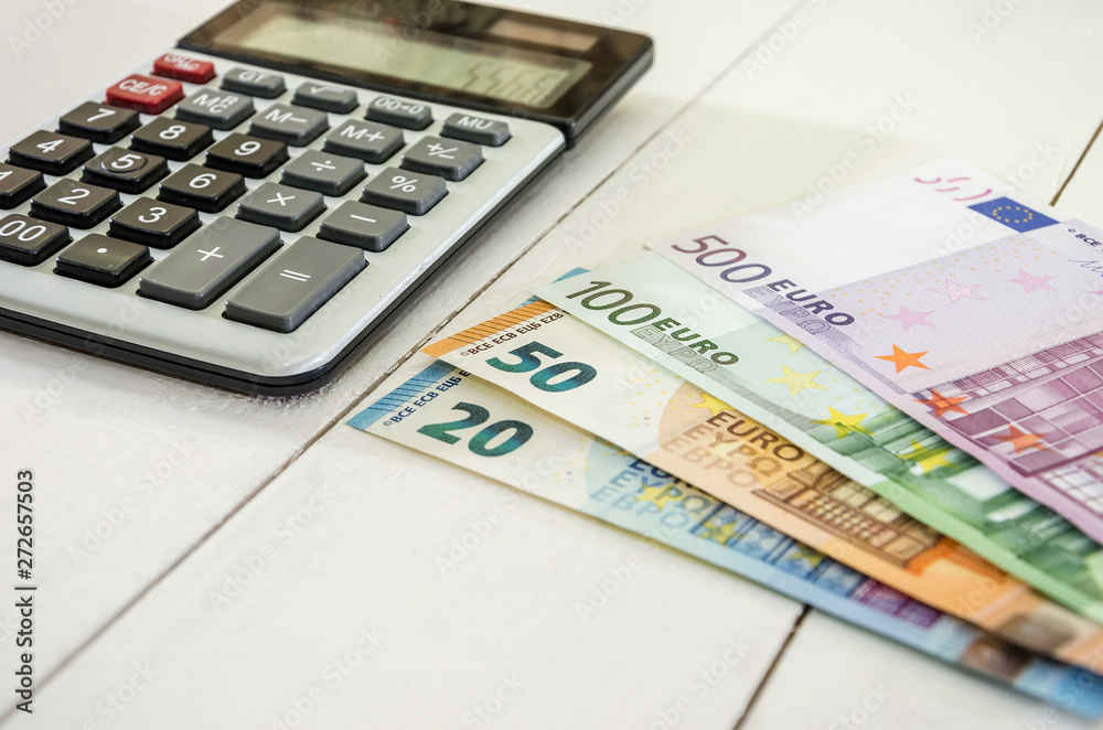 euro banknotes and calculator on white background euro banknotes and calculator on white background