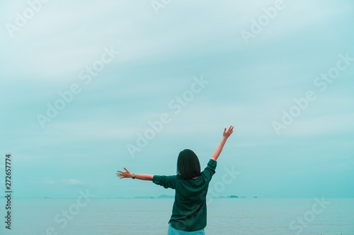 Woman rise hands up to sky freedom concept with blue sky.