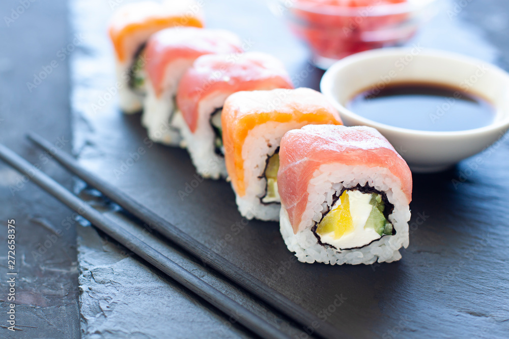 Sushi rolls on the plate with soy sauce and chopsticks. Japanese food close up Sushi rolls on the plate with soy sauce and chopsticks. Japanese food close up