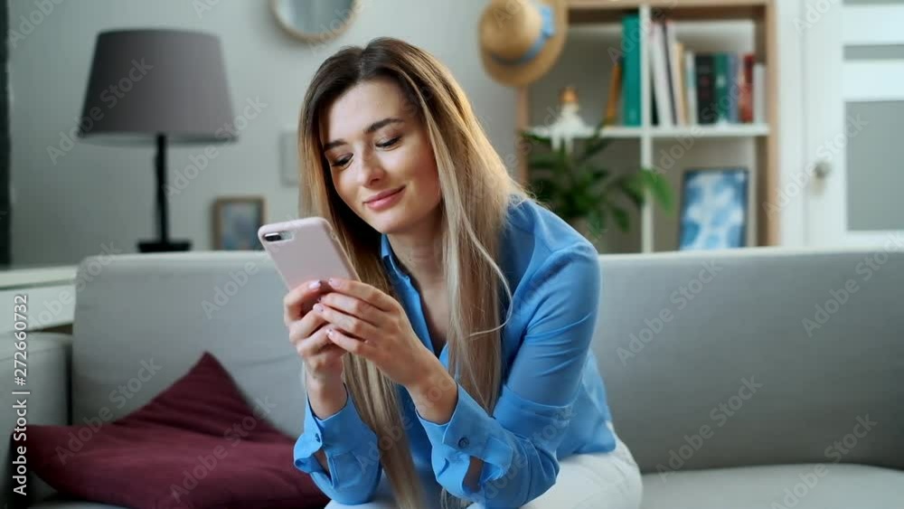 Girl using mobile device browsing the internet, staying connected at home enjoying modern lifestyle. Pretty young woman using smartphone on the couch, texting while relaxing. Girl using mobile device browsing the internet, staying connected at home enjoying modern lifestyle. Pretty young woman using smartphone on the couch, texting while relaxing.
