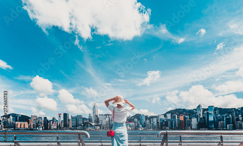 Photography Asian woman wear straw hat look at Victoria Harbor from Tsim Sha Tsui