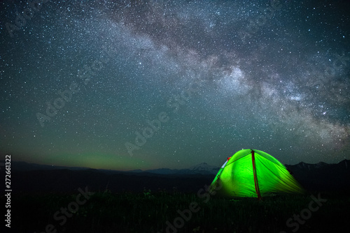 tourist tent of green color against the night sky with the Milky Way