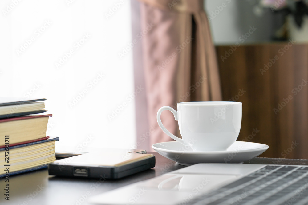 Coffee cup and laptop on table
