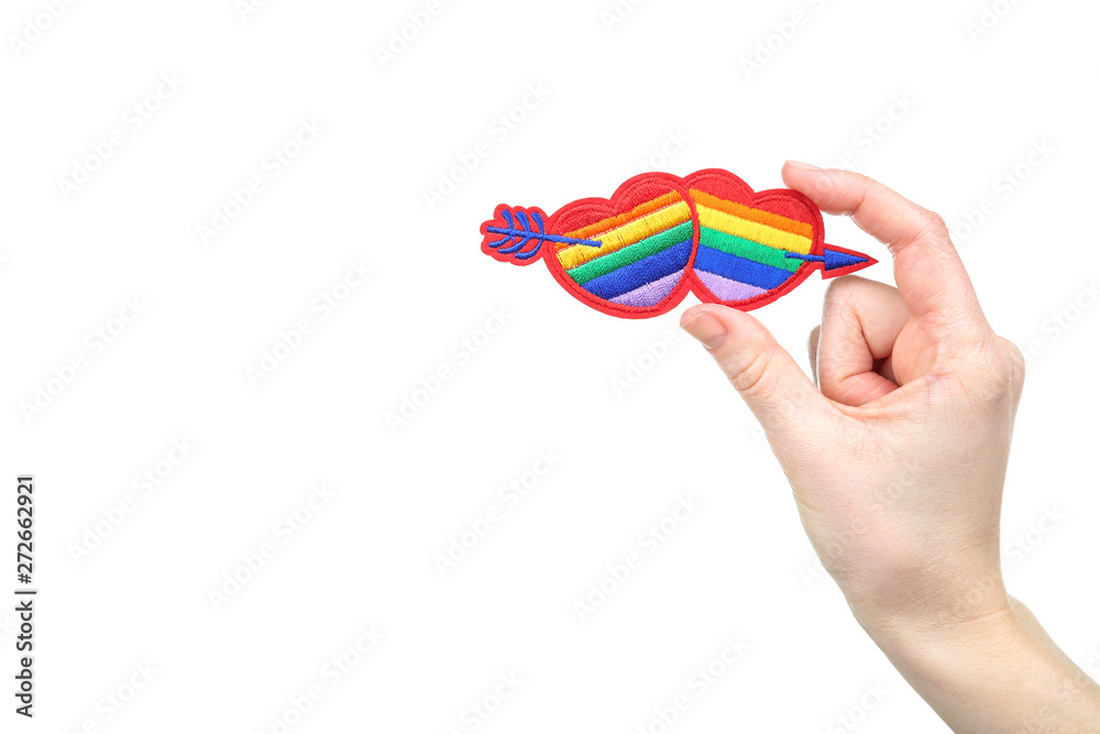 Female hands holding rainbow hearts with arrow on white background Female hands holding rainbow hearts with arrow on white background