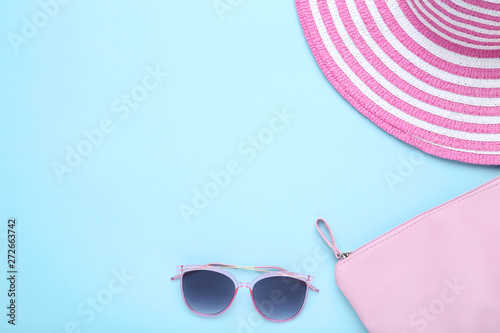 Beach hat with bag and sunglasses on blue background