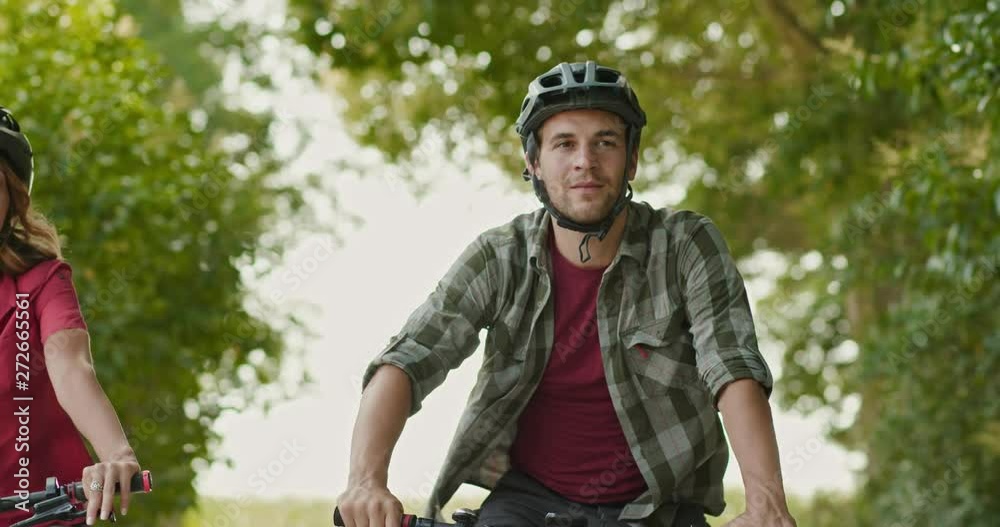 Romantic active couple riding e-bike bicycles mtb on a beautiful outdoor forest woods trail path.Wide shot.Friends italian trip in Umbria.4k slow motion Romantic active couple riding e-bike bicycles mtb on a beautiful outdoor forest woods trail path.Wide shot.Friends italian trip in Umbria.4k slow motion