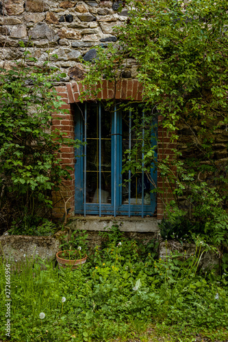 Blue window against stone wall