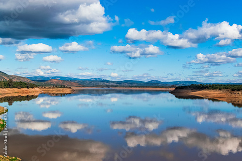 Look at the Guadalen reservoir reflecting in the water all the sky and its clouds. Photograph taken in Jaen, Andalucia, Spain.