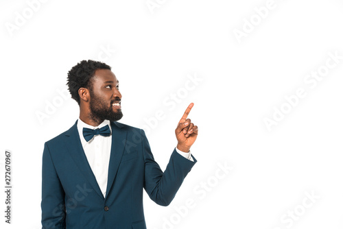 cheerful african american bridegroom pointing with finger isolated on white