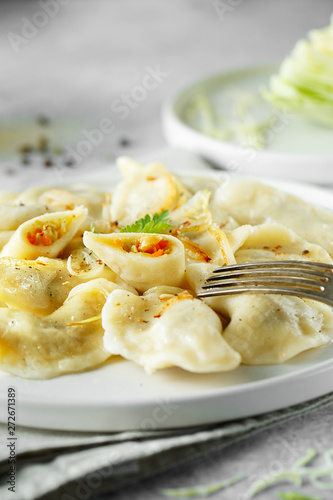 Dumplings, filled with cabbage. Russian, Ukrainian or Polish dish: varenyky, vareniki, pierogi, pyrohy. Food photo