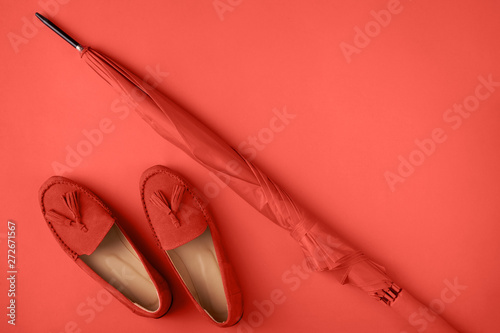 Coral shoes and umbrella on coral background