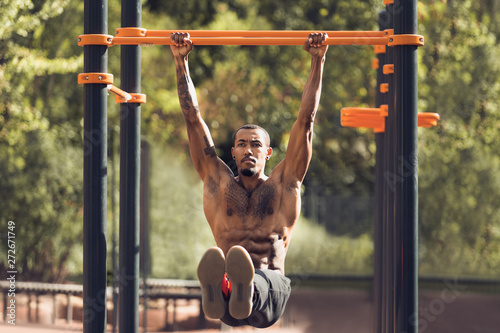 Afro Sporty Man Doing L-Sit On Horizontal Bar