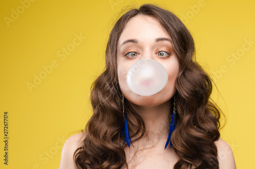 Charming young girl blowing bubble from chewing gum