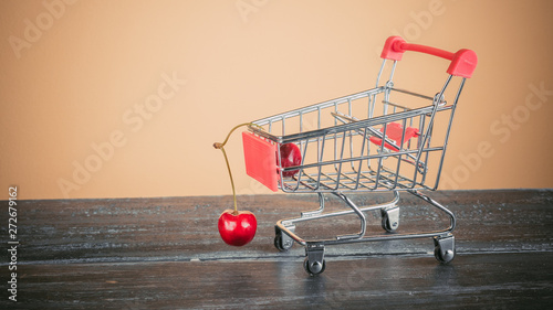 mini cart with cherries on yellow background