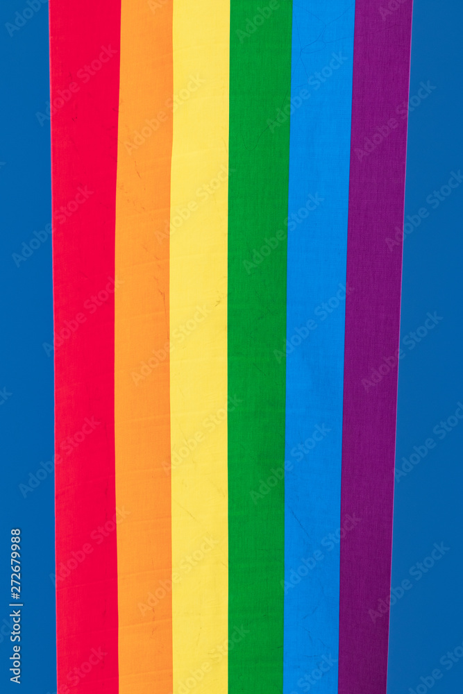 Rainbow backgrounds fabric. Closeup of rainbow linen canvas with colorful textured prallel vertical lines fabric macro. Outdoor LGBT background image.