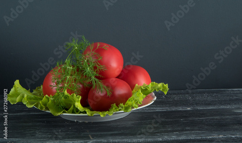 lettuce, tomatoes and dill on a white plate