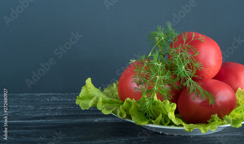 lettuce, tomatoes and dill on a white plate