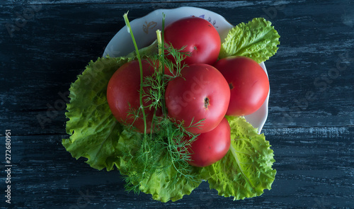lettuce, tomatoes and dill on a white plate