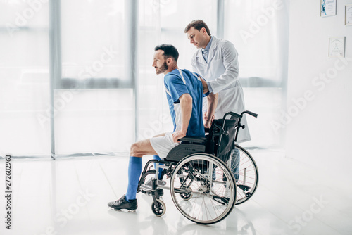 Physiotherapist helping handicapped football player in Wheelchair during recovery © LIGHTFIELD STUDIOS