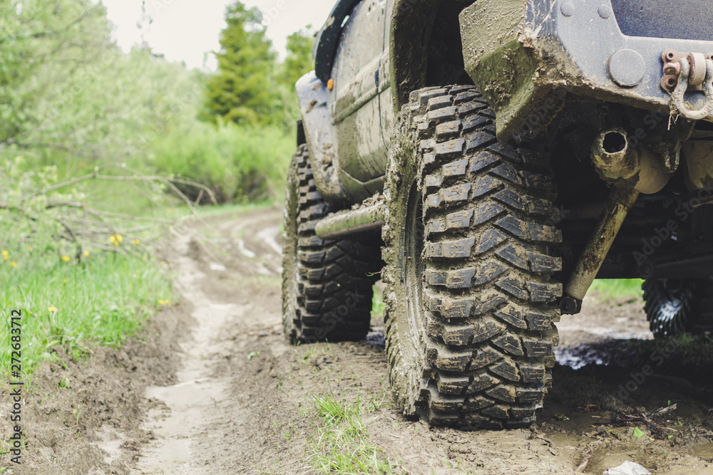 Fototapeta premium Dirty cars and wheels in the mountains. Swamp on the tires. Trips offroad across Ukraine. View of the Carpathian Mountains.