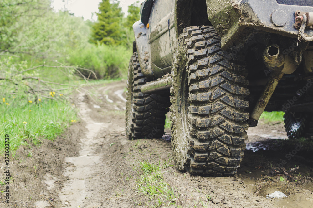 Fototapeta premium Dirty cars and wheels in the mountains. Swamp on the tires. Trips offroad across Ukraine. View of the Carpathian Mountains.