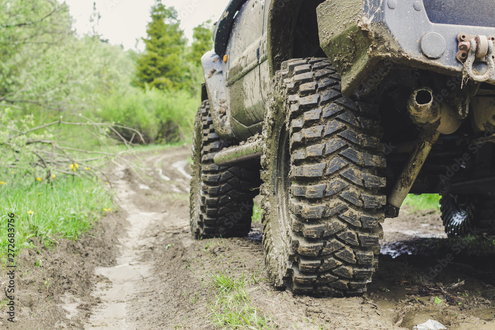 Fototapeta premium Dirty cars and wheels in the mountains. Swamp on the tires. Trips offroad across Ukraine. View of the Carpathian Mountains.