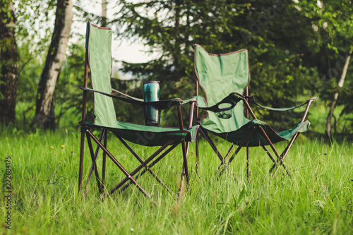 Picnic in the mountains with folding chairs and a table. The car and the rubber wheel. Carpathian mountains