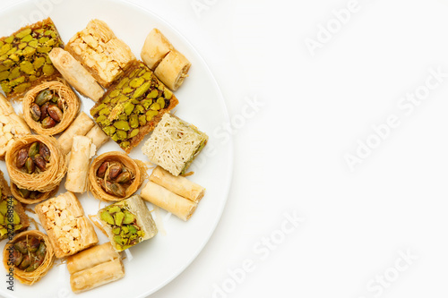 Obraz na płótnie Traditional oriental sweets in white plate with different nuts on a white table, top view, copy space w salonie