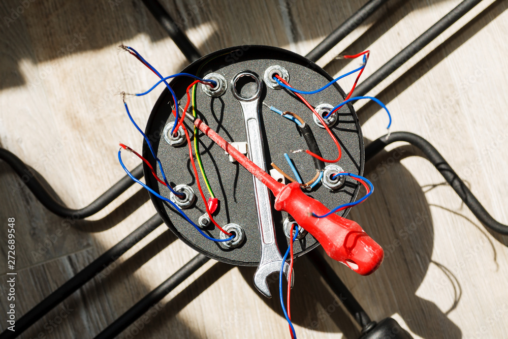 Obraz premium Chandelier with wires and tools on the floor, preparation to installation