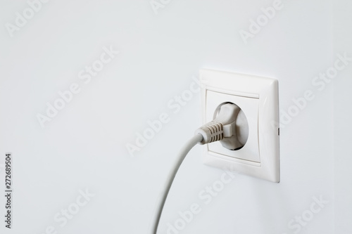 Obraz na płótnie Electric outlet with plugged in wire on white wall w salonie