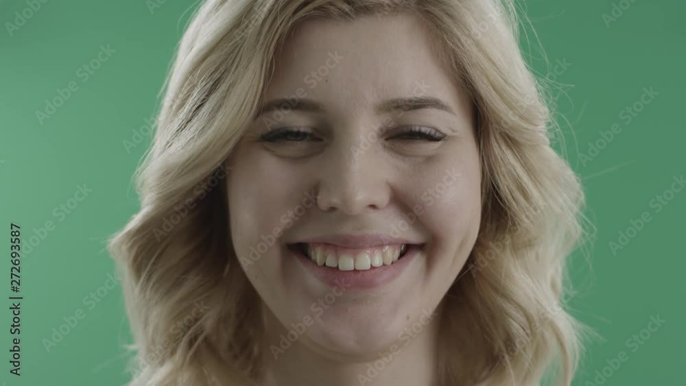 Happy young woman smiles and kisses against green screen Happy young woman smiles and kisses against green screen