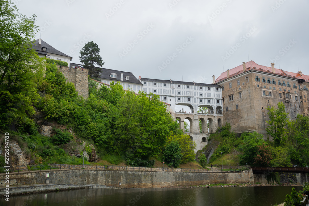 Fototapeta premium Panoramic landscape view on river Vltava in the historic city of Cesky Krumlov with famous Church city is on a UNESCO World Heritage Site captured during spring with nice sky and clouds