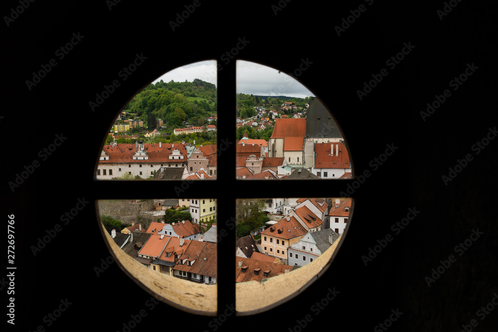 View through the window on the tower of the castle and the view of Cesky Krumlov with the famous Cesky Krumlov Castle, the Church of the World Heritage Site