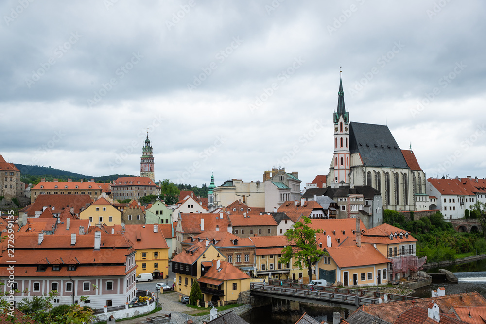 Fototapeta premium Panoramic landscape view of the historic city of Cesky Krumlov with famous Church city is on a UNESCO World Heritage Site captured during spring with nice sky and clouds