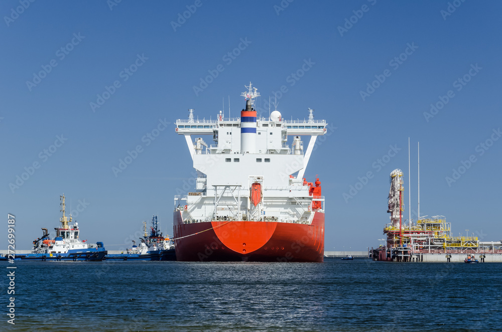 GAS CARRIER AND LNG TERMINAL - The big ship maneuvers in the mooring port at the wharf