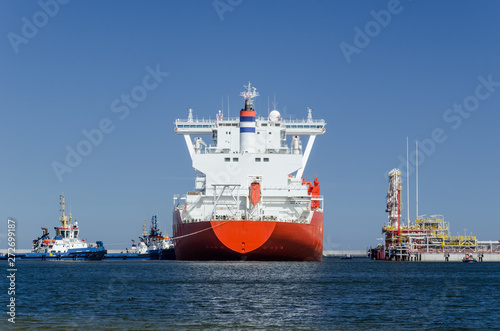 GAS CARRIER AND LNG TERMINAL - The big ship maneuvers in the mooring port at the wharf