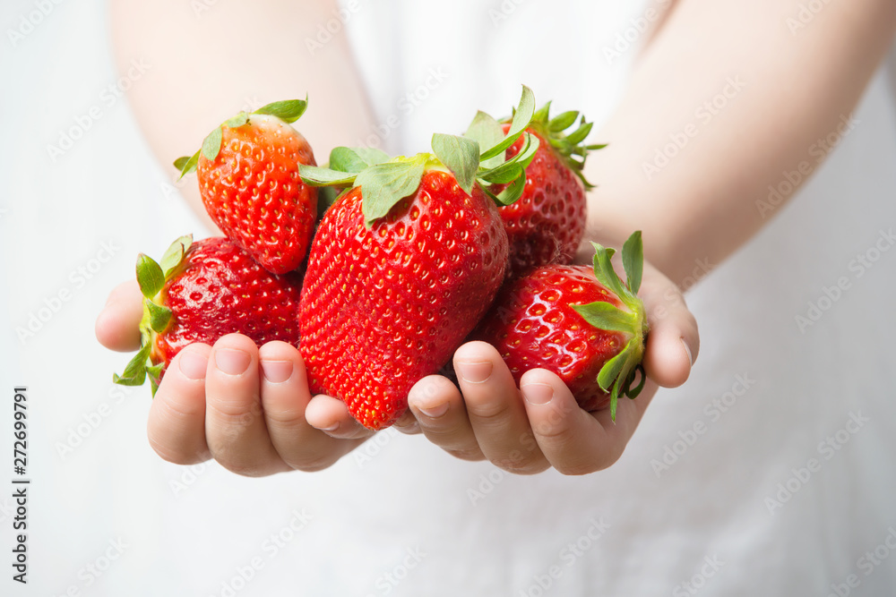 Obraz premium Child hands holding fresh ripe strawberries