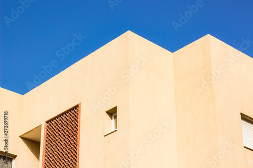 common living building geometric shapes and lines in foreshortening from below photography on blue sky background  © Артём Князь