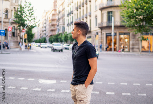 Young fashionable handsome man on the street of modern city. He looks happy