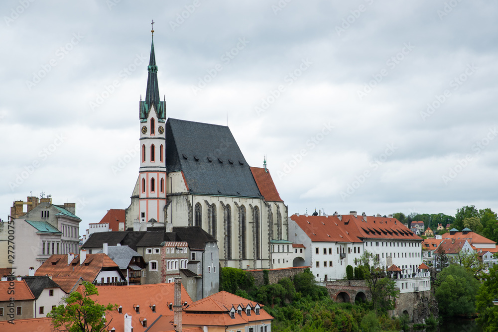 Fototapeta premium Panoramic landscape view of the historic city of Cesky Krumlov with famous Church city is on a UNESCO World Heritage Site captured during spring with nice sky and clouds
