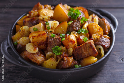 Tasty food: succulent beef with fried potatoes, onion and garlic. Country-style roasted potatoes with meat
